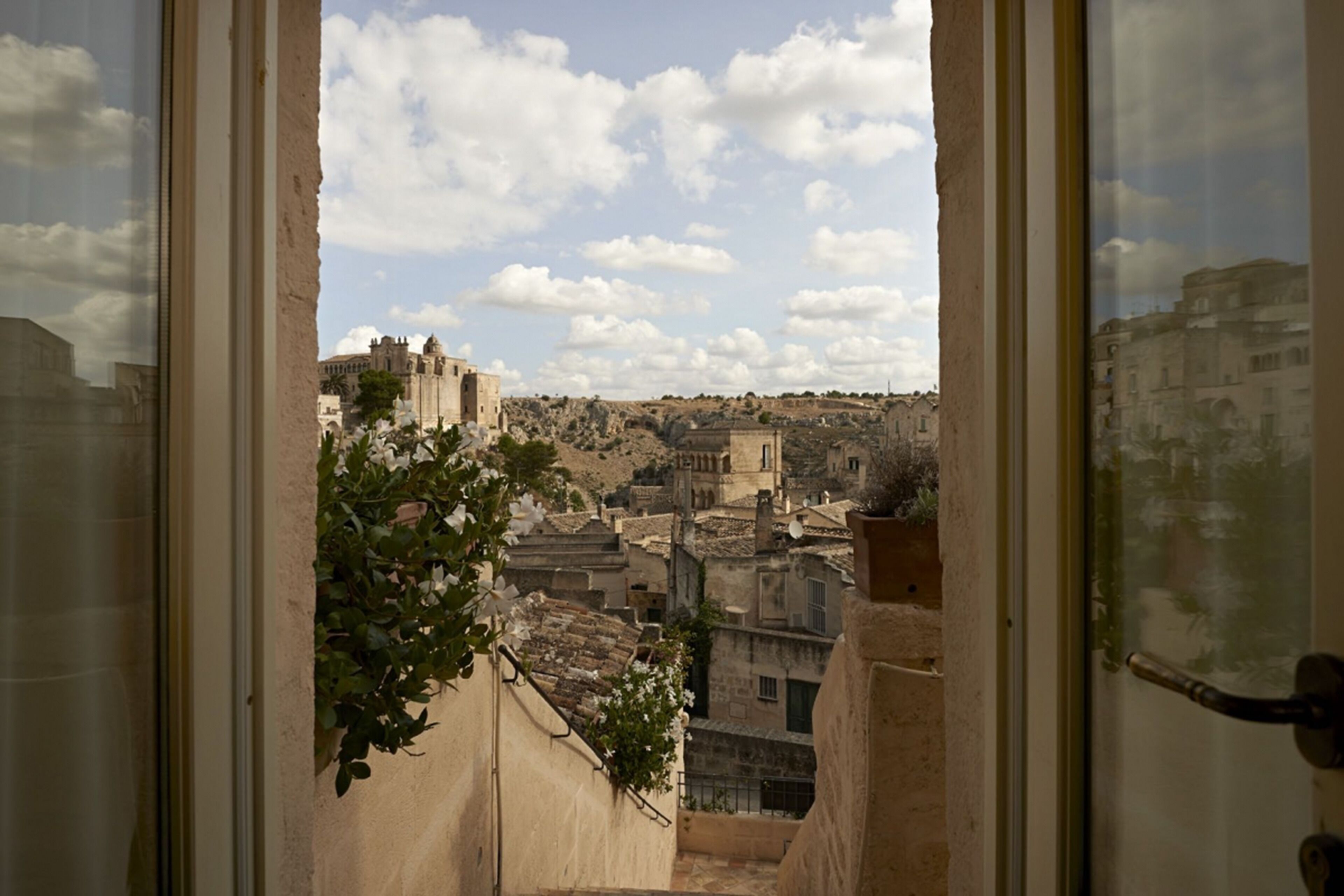 Vista desde una ventana con vista a un pueblo histórico, con edificios y un castillo.
