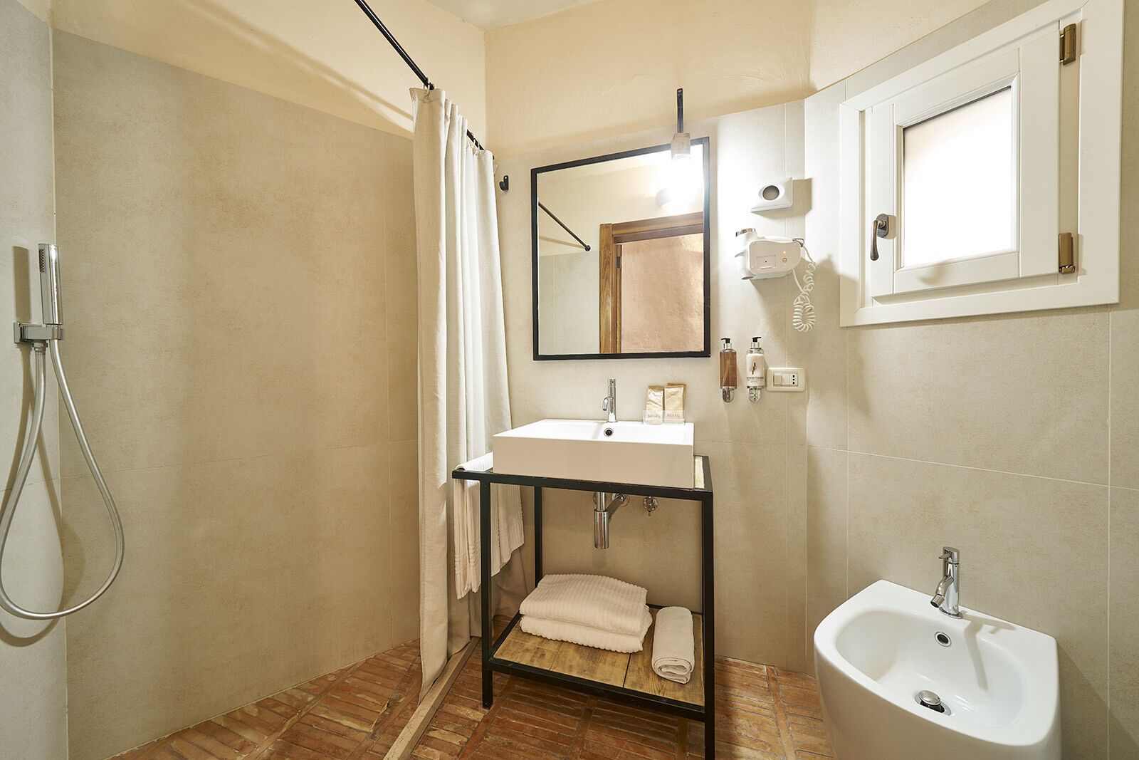 A bathroom with a shower, a sink, and a bidet.
