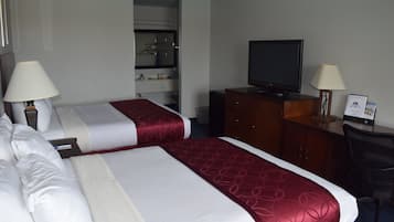 A hotel room with two beds, a TV, a desk, and a wardrobe.