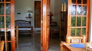 A wooden room with a bed, a desk, and a window. - Sea Turtle House (Moalboal)