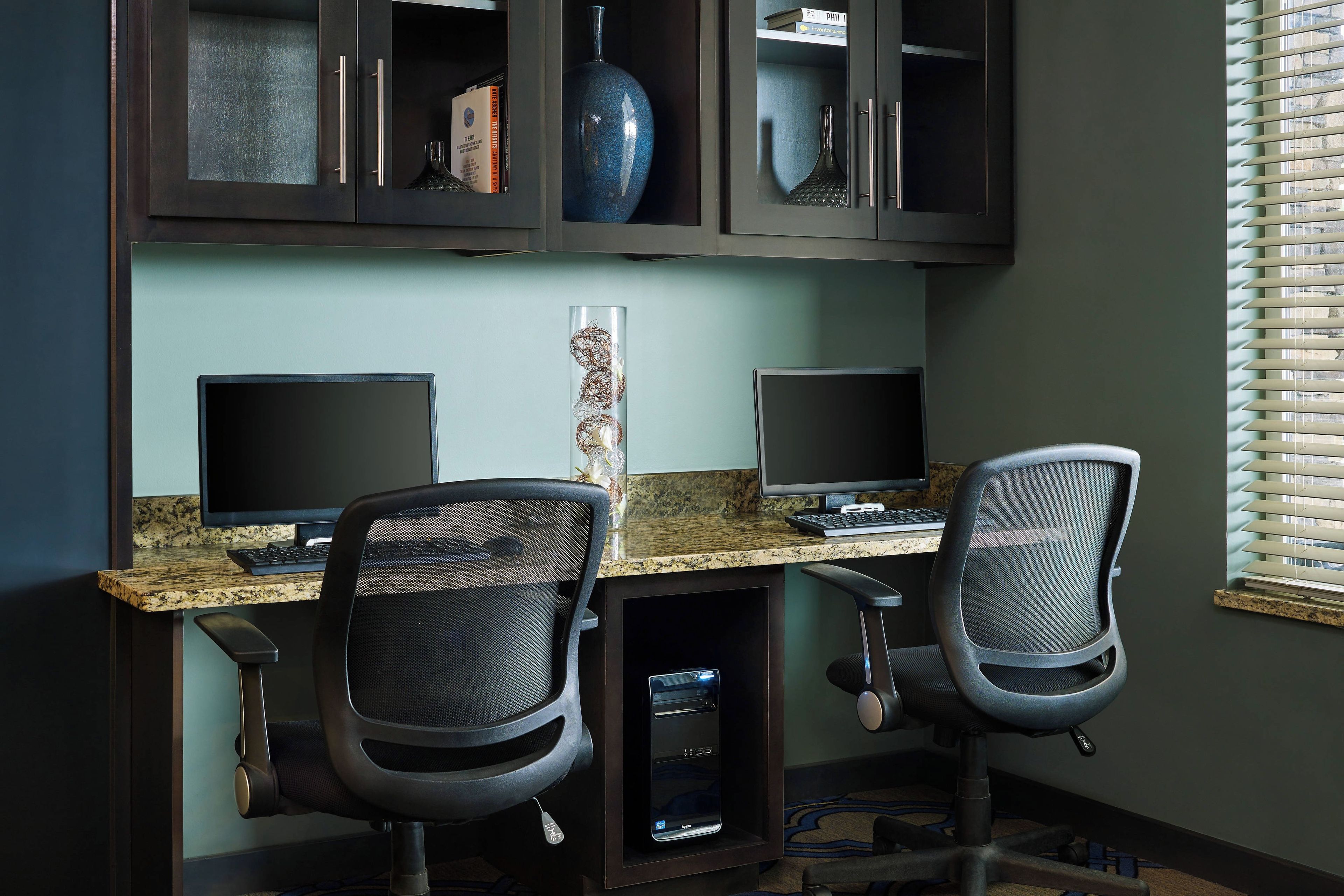A workspace with two desks, chairs, and a computer setup.