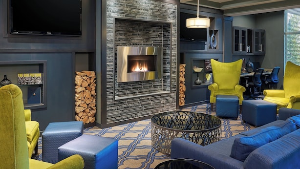 Una sala de estar moderna con chimenea, asientos cómodos y un televisor de pantalla plana.