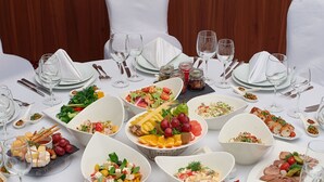 A round table set for a formal meal with various dishes, glasses, and cutlery. - Hilton Garden Inn Astana (Astana)