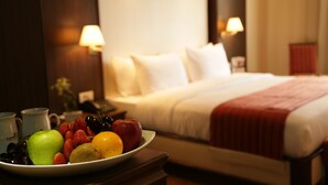 A hotel room with a bed, bedside lamps, and a fruit bowl on a nightstand. - Golden Lili Resort & Spa (Aley)