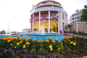 Un edificio con un atrio central circular, varios balcones y una fuente.
