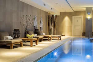 Una piscina techada, sillones reclinables de piscina