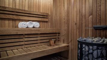 A wooden sauna with benches and a stone heater.