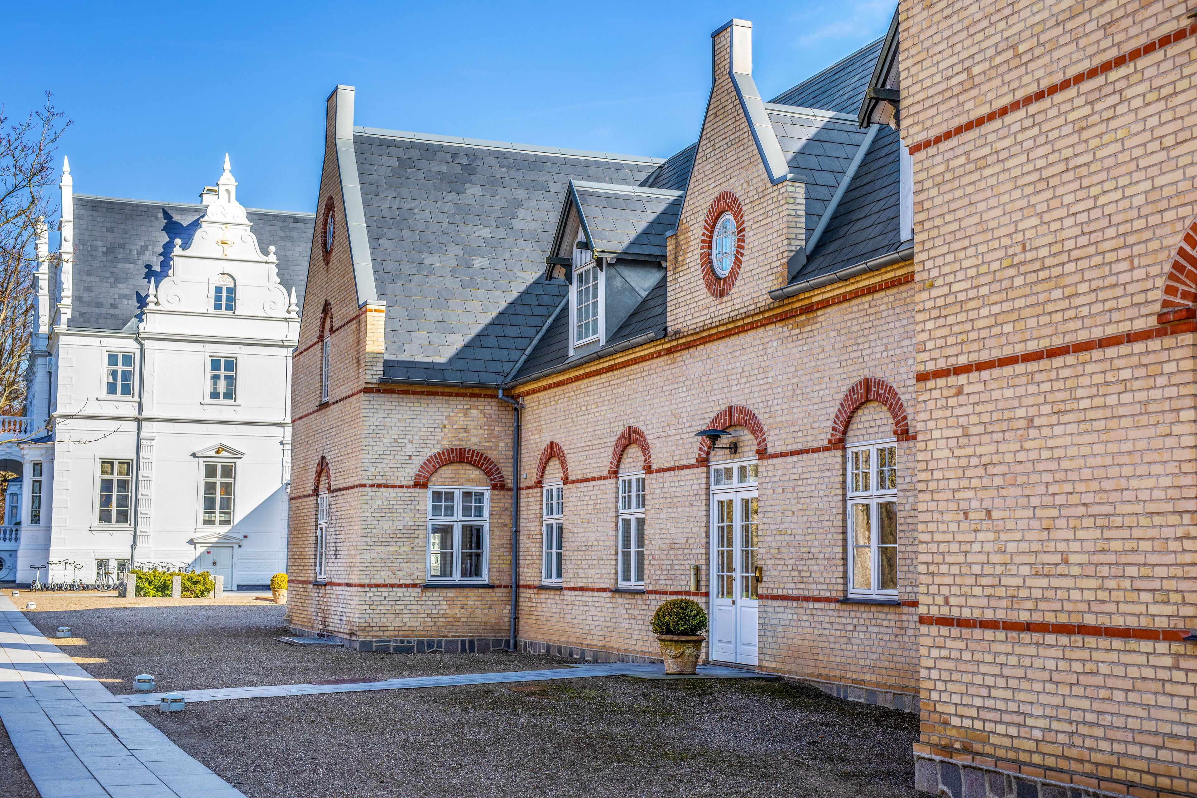 A historic building with a symmetrical facade, arched windows, and a central door.
