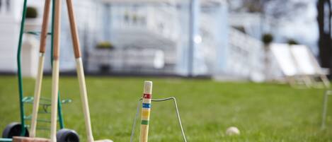 Un juego de cricket sobre un campo cubierto de hierba, con un poste de meta y borras.