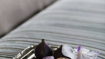 Un plateau contenant des macarons, des figues et une fleur, posé sur une surface en tissu à rayures.