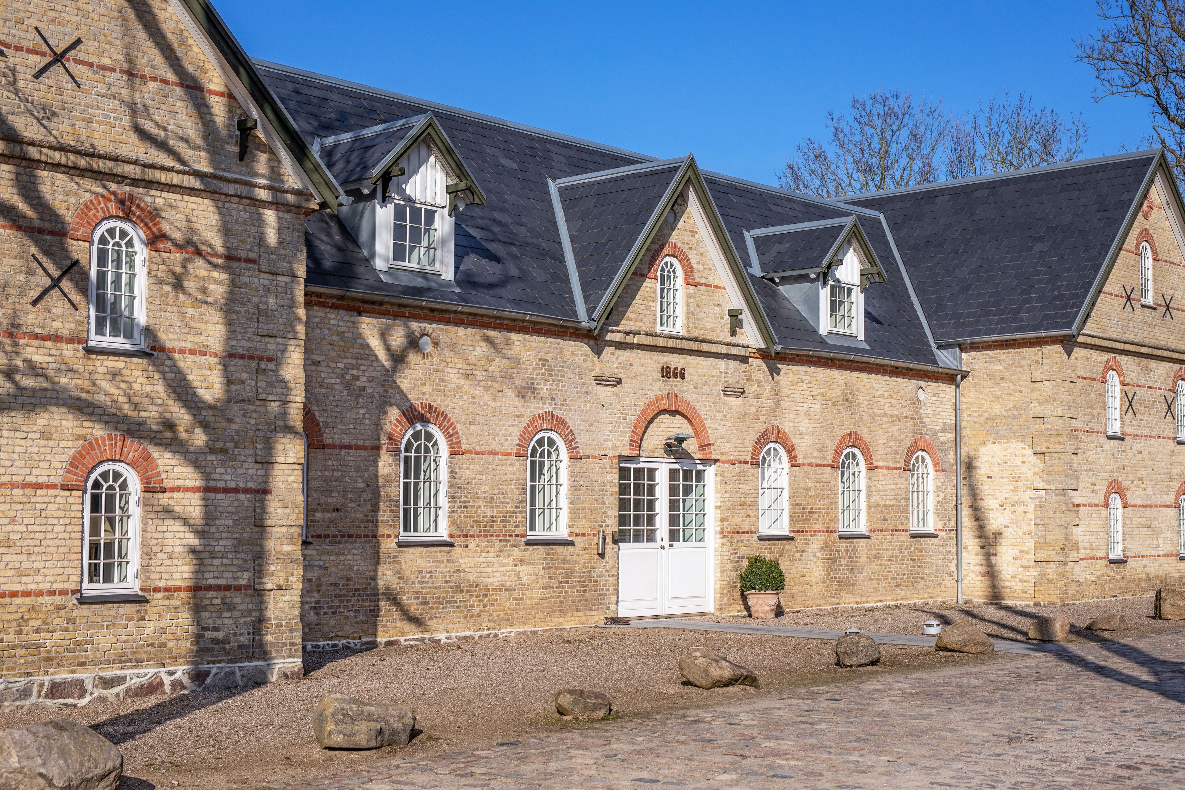 Ein historisches Backsteingebäude mit Rundbogenfenstern und einem zentralen Eingang.