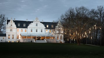 A large, white building with multiple windows and a prominent entrance.