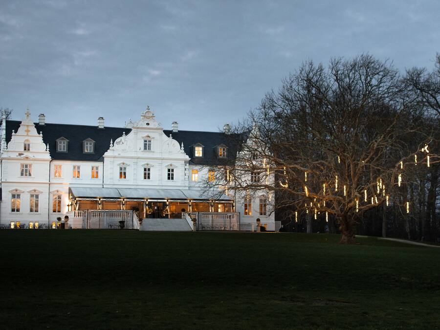 Ein großes, weißes Gebäude mit vielen Fenstern und einem markanten Eingang.