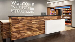 A reception desk with a wooden panel design and a "Welcome to the Key Stone State" sign. - Hampton Inn & Suites York South (York)