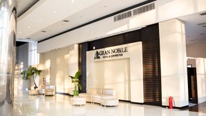 A modern hotel lobby with a reception desk, seating area, and a sign for 'GRAN NOBLE HOTEL & CONVENTION'. - Nobile Hotel Convention Ciudad Del Este (Ciudad Del Este)