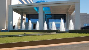 A modern building with a glass facade and a fountain in front. - Nobile Hotel Convention Ciudad Del Este (Ciudad Del Este)
