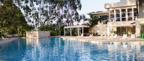 Una piscina al aire libre, camas de piscina gratis, sombrillas