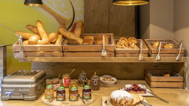 Un buffet proposant une variété de pains, de viennoiseries et de condiments.
