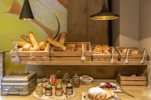 Ein reichhaltiges Buffet mit verschiedenen Brotsorten, Gebäck und Beilagen.