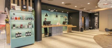 A reception area with a counter, shelves with products, and a modern ceiling design.