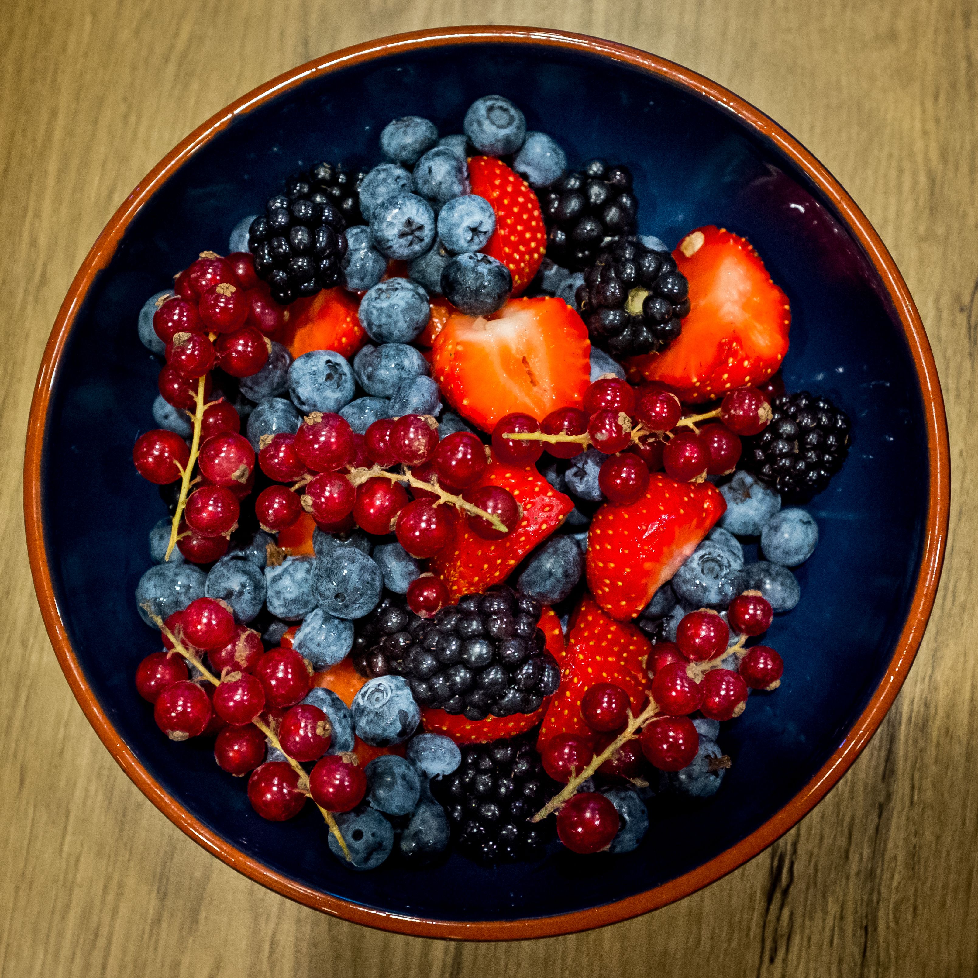 A bowl filled with mixed berries and grapes.