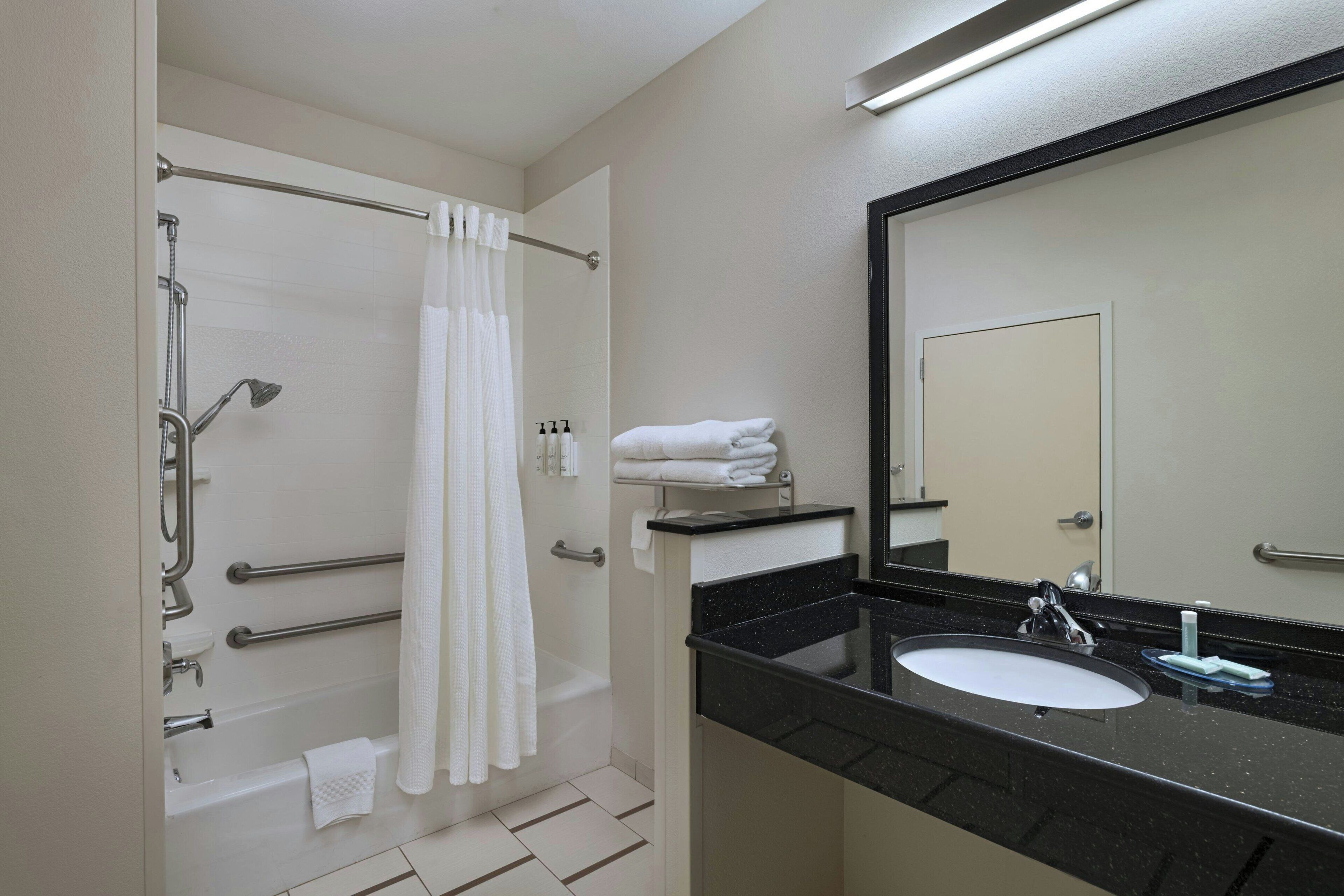 Un bagno con vasca, doccia e lavandino.