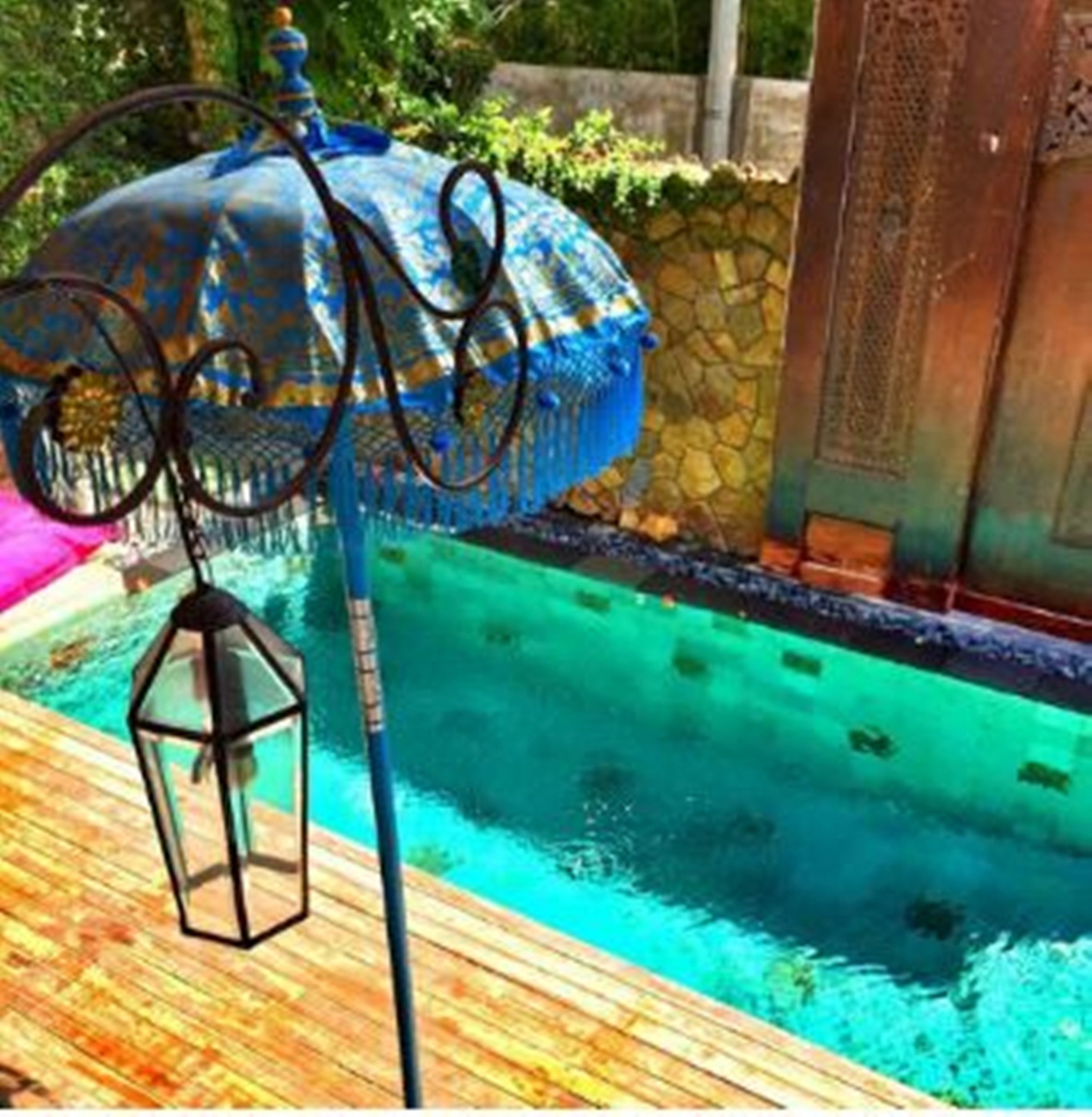 Piscina com deck de madeira e estrutura metálica decorativa.