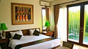 Habitación de hotel con una cama grande, un cuadro en la pared, una lámpara verde y vistas a zonas verdes por la ventana.
