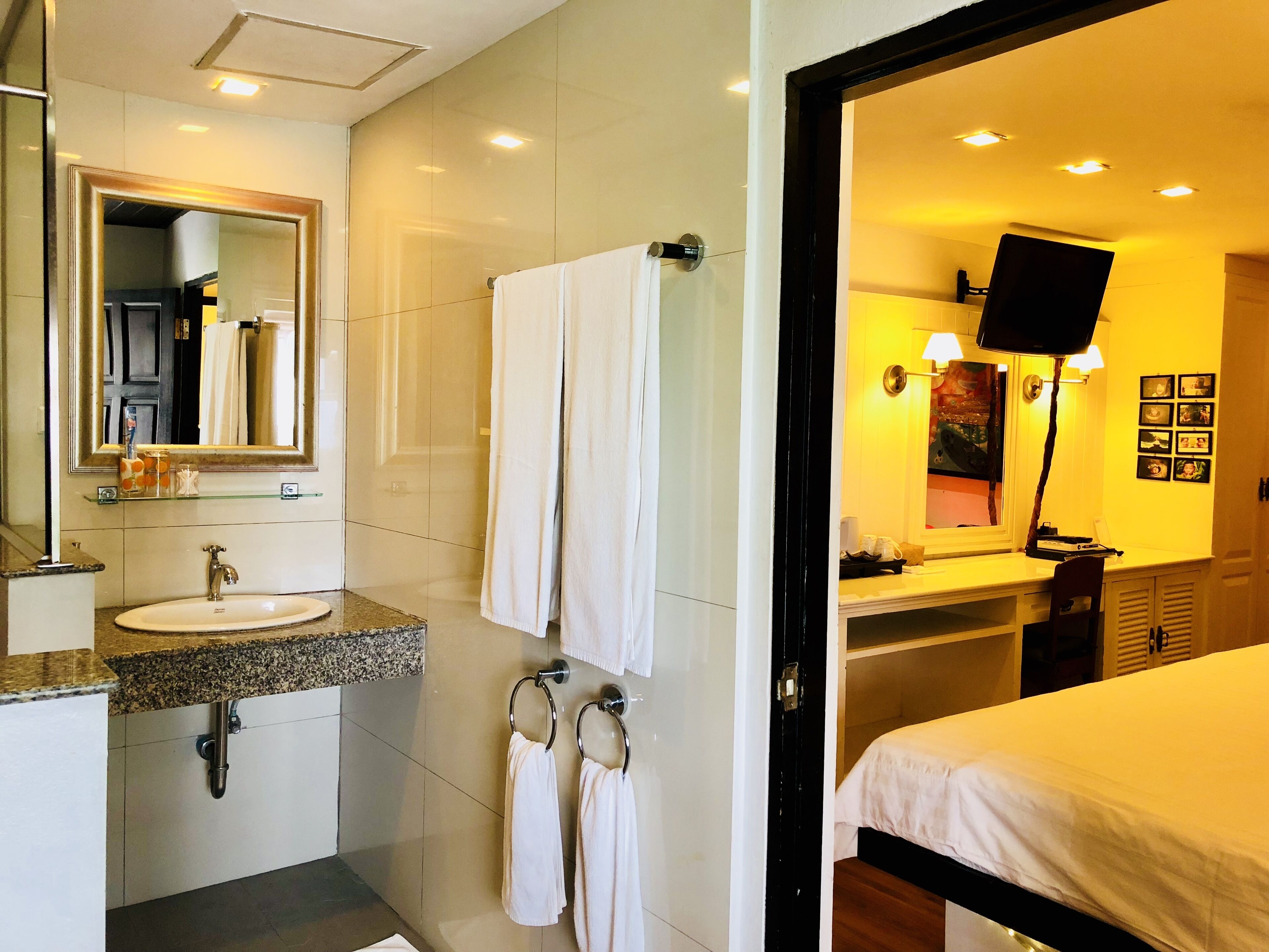 A modern bathroom with a sink, mirror, and towel rack.