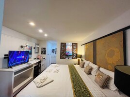 Una habitación de hotel con cama, televisión, escritorio y armario.