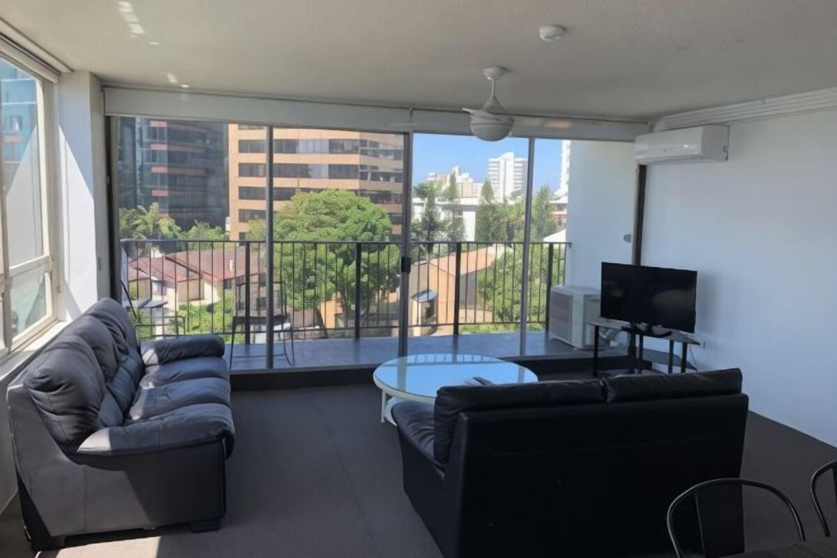 Un balcon avec un canapé, une table basse et un téléviseur.