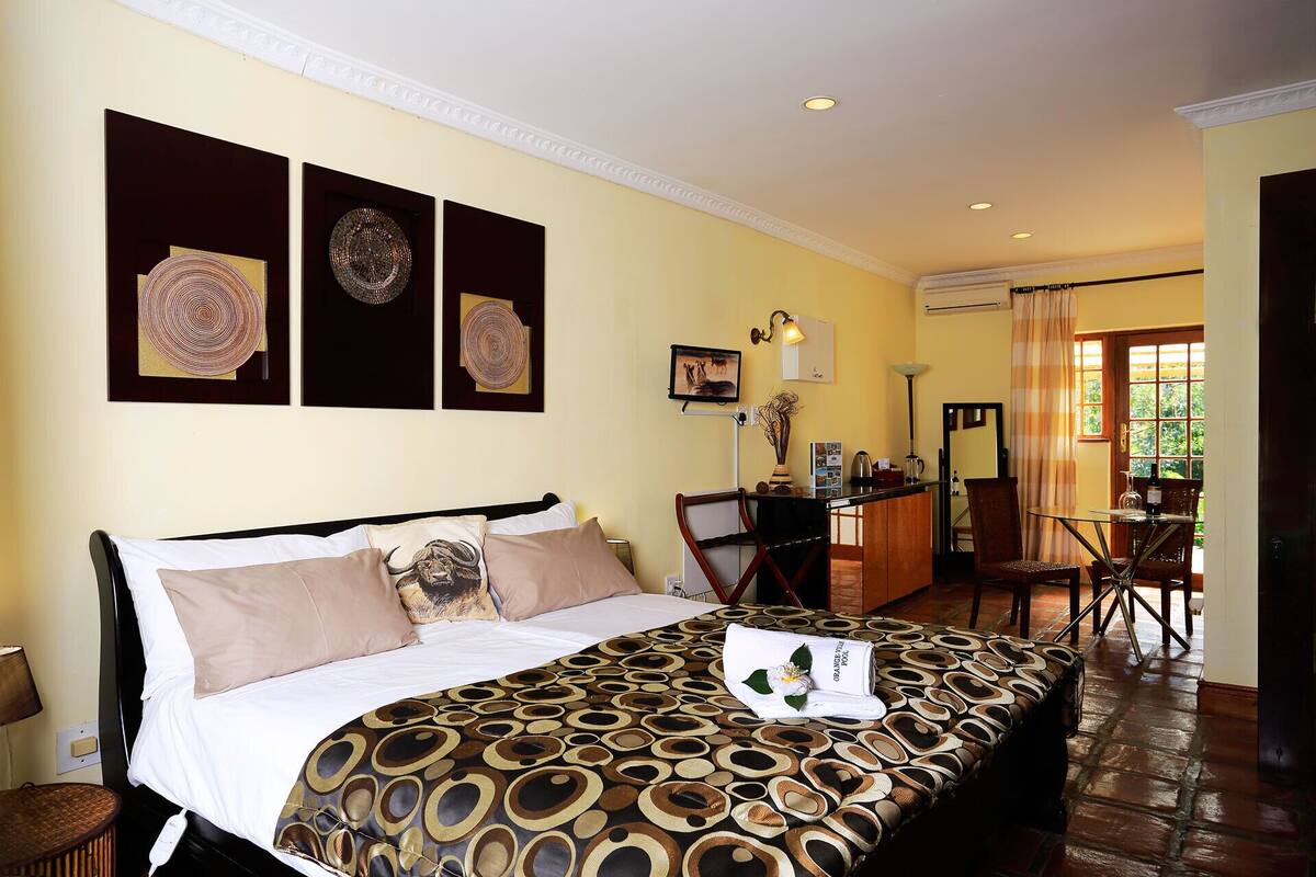 Une chambre d’hôtel comprenant un lit, un bureau, une chaise et une table à manger.