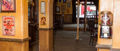 An interior with a central archway, framed pictures, and various signs including one for 'Colman's Mustard'.