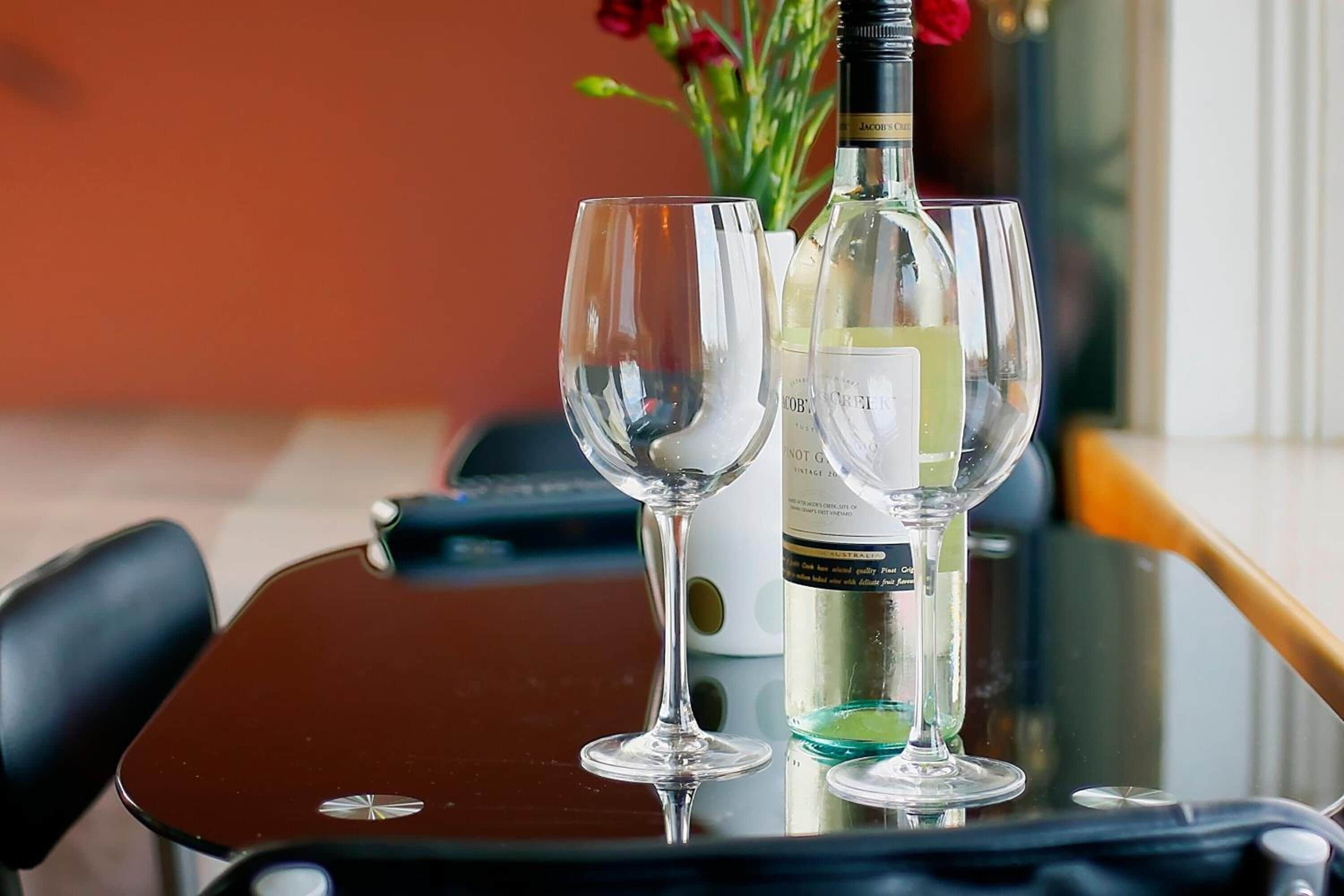 Una mesa con dos copas de vino y una botella.