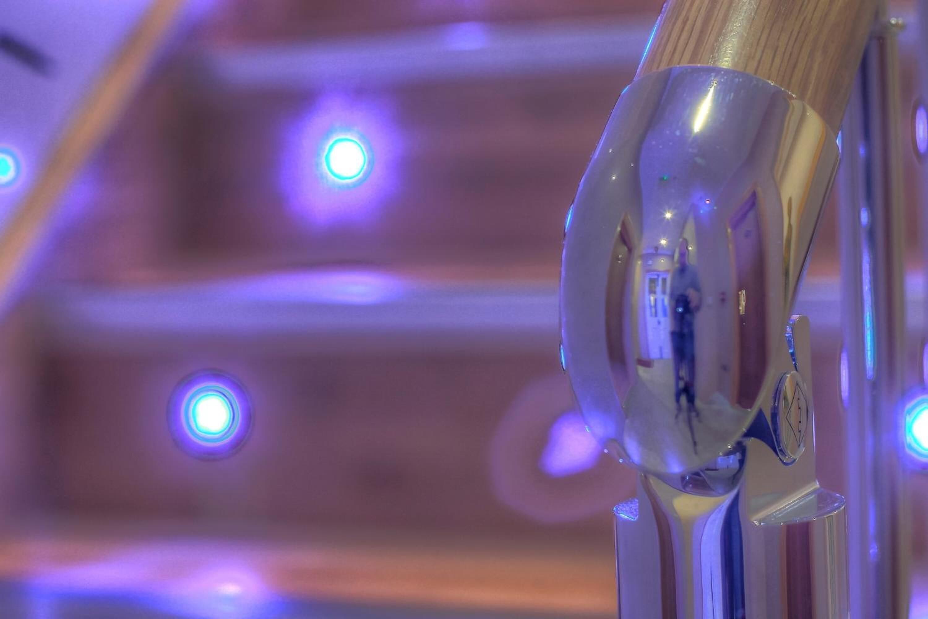 A close-up of a metallic object with a reflective surface, possibly part of a piece of furniture or equipment.