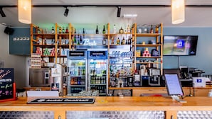 A bar area with shelves of bottles and a digital menu display.