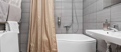 Un baño moderno con bañera, inodoro y lavamanos.