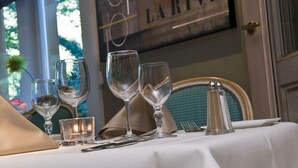 Una mesa servida con copas de vino, un salero y un vaso pequeño.