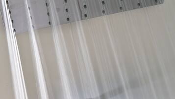 A shower with a metal grate and water flowing down.
