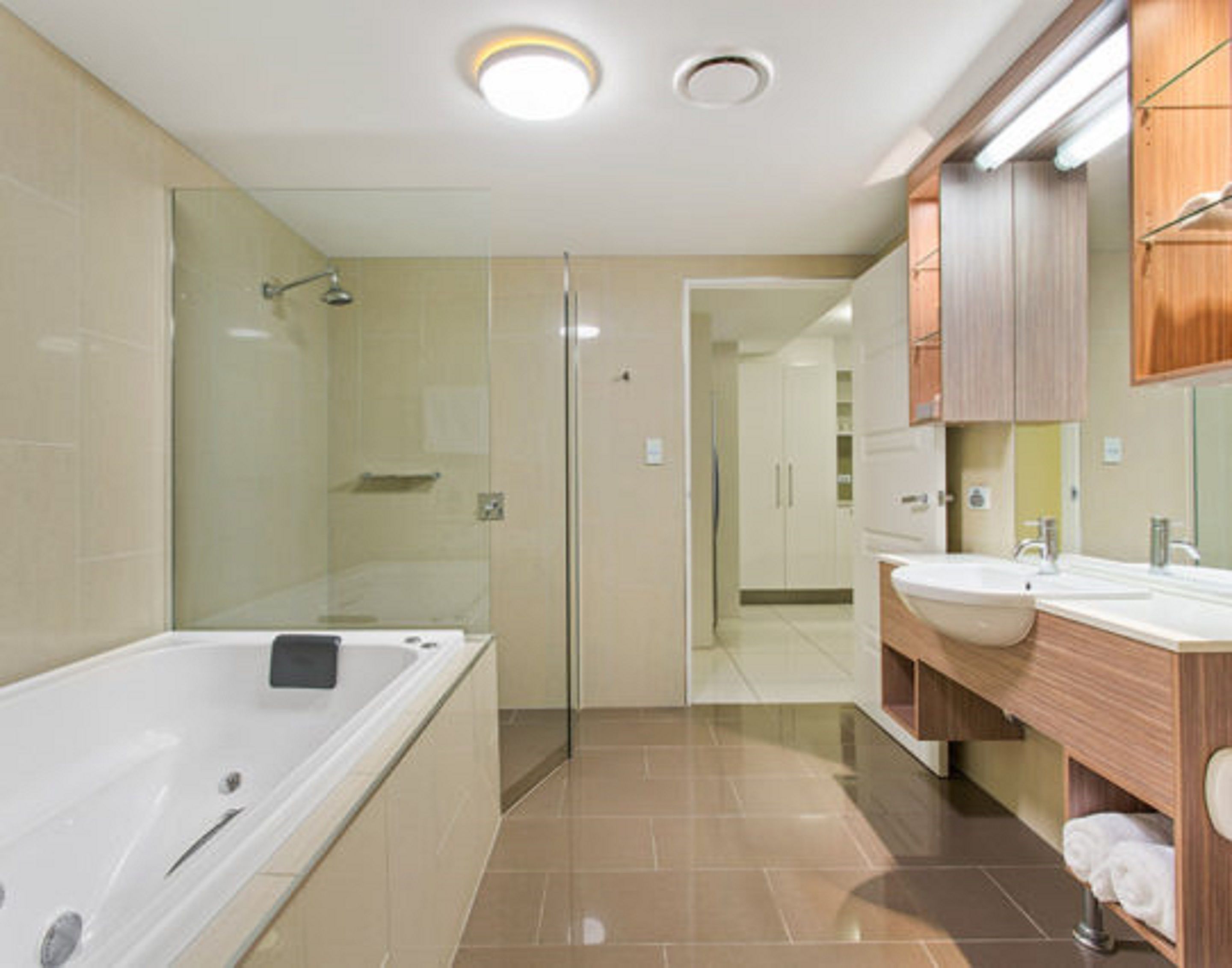 Un baño moderno con ducha envuelta en vidrio, una bañera independiente y un tocador con lavabo y espejo.