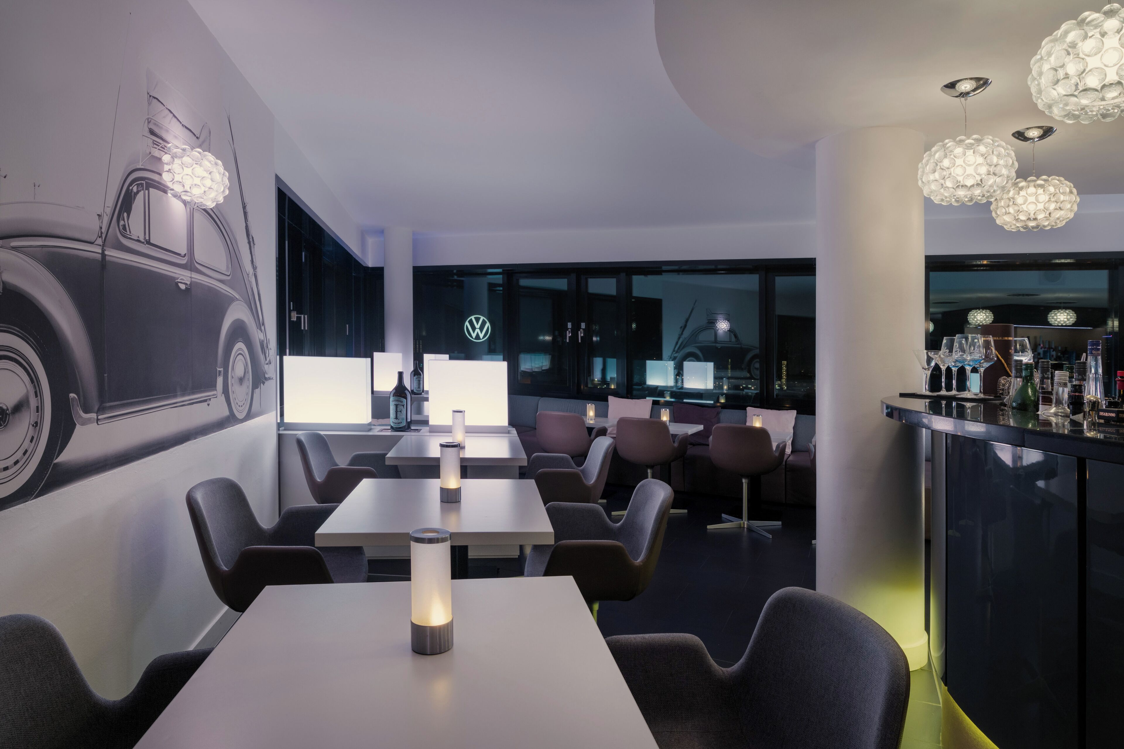 Ein modernes Restaurant mit Tischen, Stühlen und einer Bar.