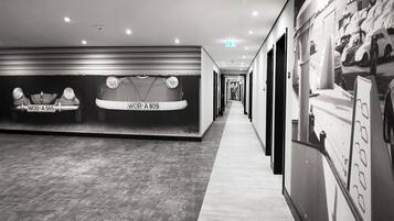 Un pasillo con una exhibición de automóviles y una pared con imágenes de coches.