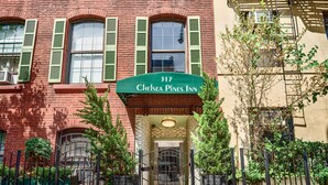 A red brick building with a green awning displaying '317 Chelsea Pines Inn'. - Chelsea Pines Inn (New York)