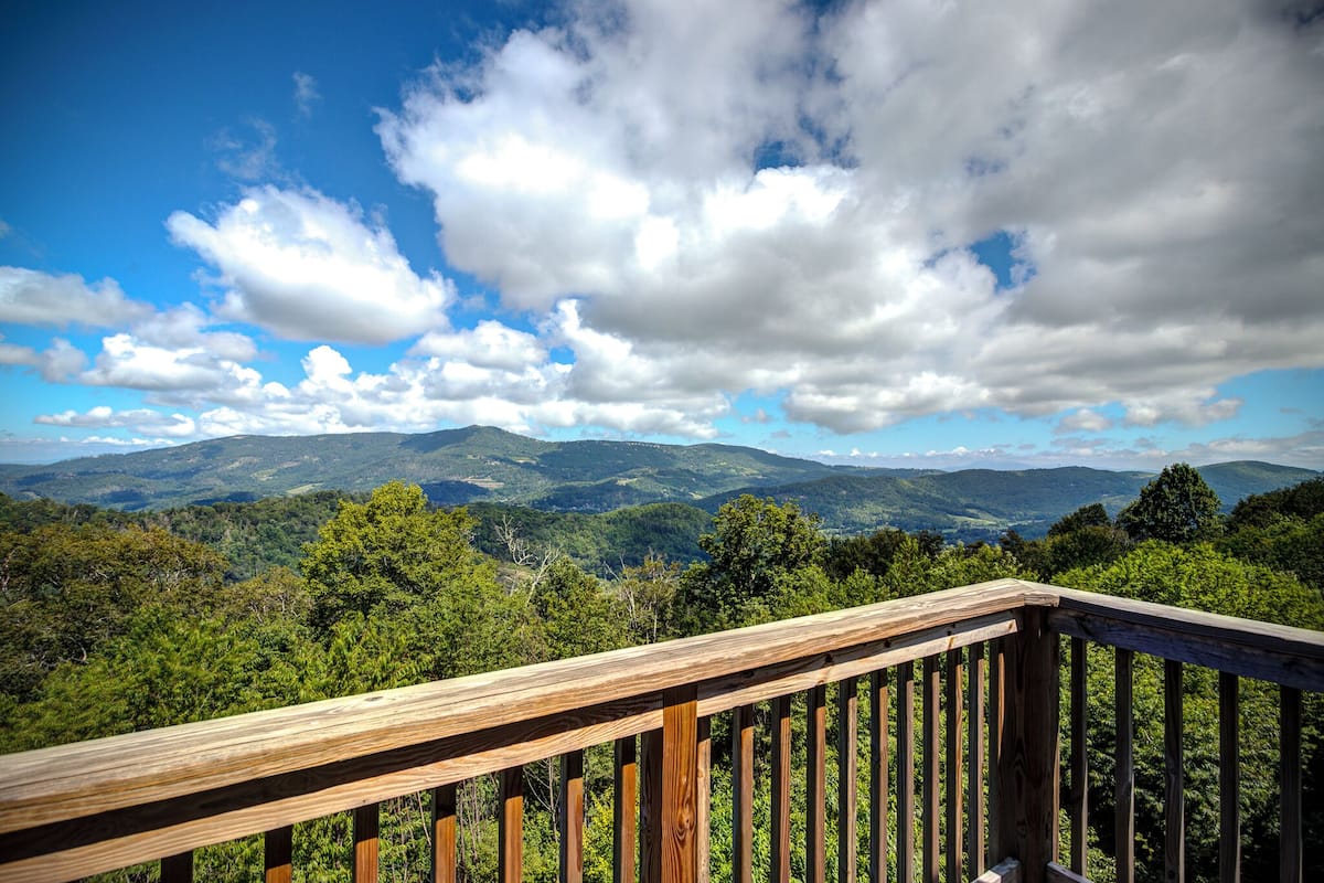 A wooden deck with a view of a mountainous landscape.