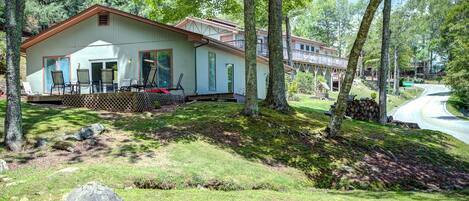 A cabin with a porch, large windows, and a deck.