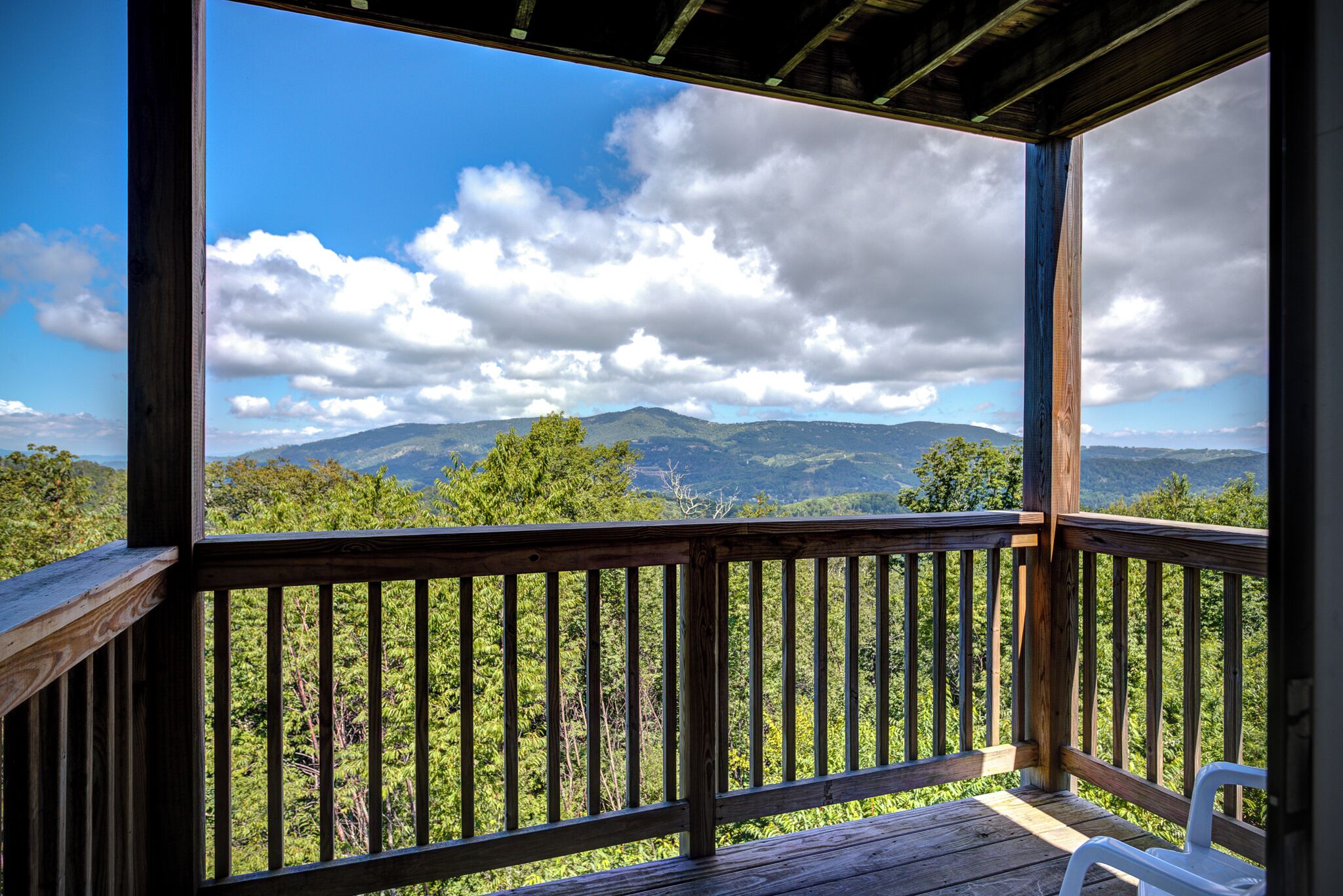 A wooden deck with a view of a mountainous landscape.