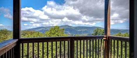A wooden deck with a view of a mountainous landscape.