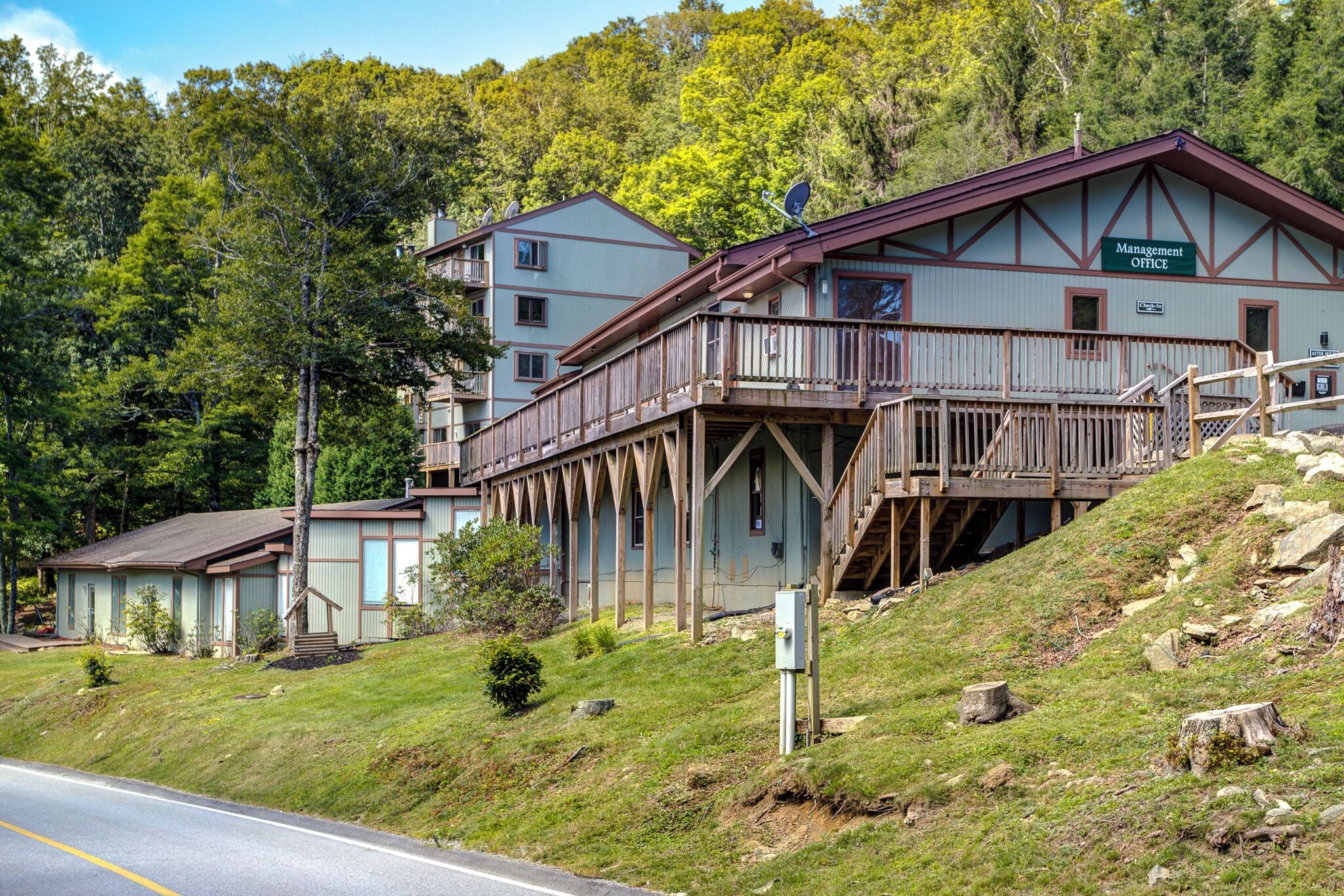 A two-story building with a 'Management Office' sign, wooden balconies, and a sloped roof.