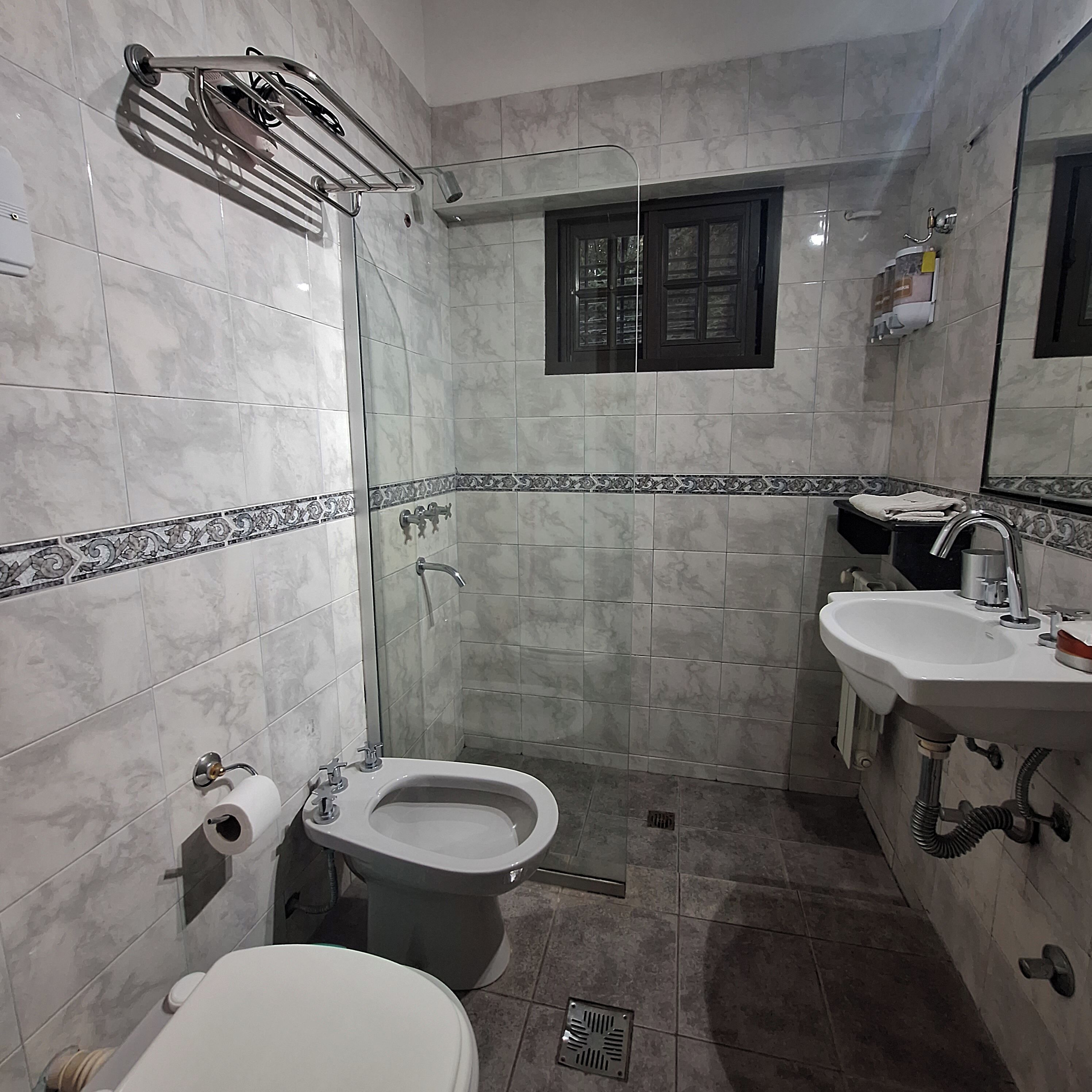 Un baño con inodoro, bidé y lavabo.