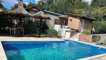 Piscine extérieure, parasols de plage, chaises longues